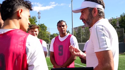 Soccer coach giving instructions to young players on the field