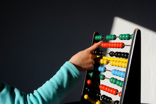 Boy calculating with colorful abacus at home