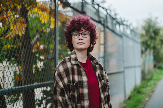 Teenager with curly hair and eyeglasses outdoors in autumn park