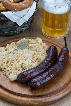 Plato de madera con chucrut y salchichas de cerdo ahumadas
