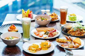 Luxurious breakfast brunch spread with variety of sweet, savory dishes, fresh juice in elegant dining setting by window. Opulent buffet, gourmet cuisine, indulgent meal concept.