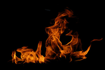 Blazing fire and glowing flames on a dark background perfect for creative design and visual...