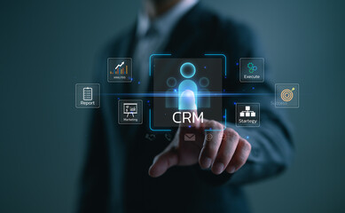 Businessman touching CRM icon on digital interface with marketing, strategy, analytics, and customer success elements, representing customer relationship management and business growth.