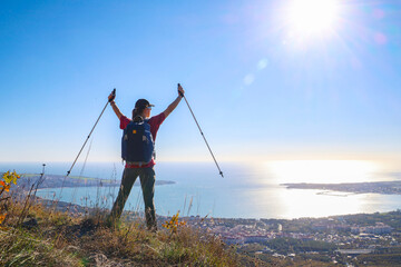 young girl with a backpack is hiking alone in nature