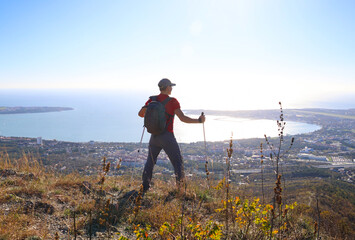 young manl with a backpack is hiking alone in nature