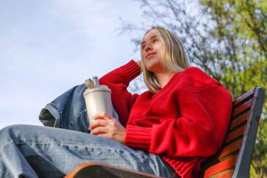 Woman relaxing outdoors with hot drink practicing mindfulness and self-care