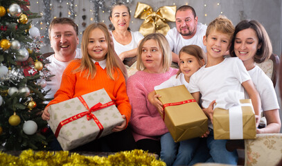 Family with children holding gifts in christmas interior
