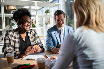 Diverse business people laughing during office meeting