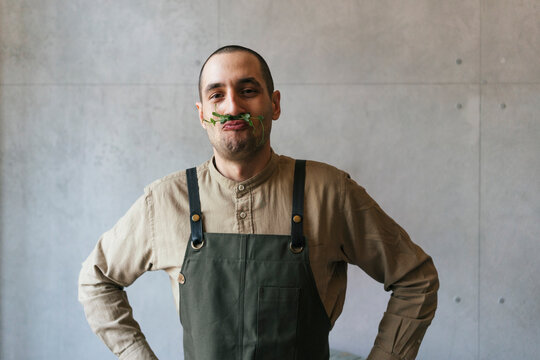 Portrait of man making nonsense with microgreen plant