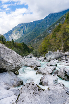 Vertical View of the Soča River Blocked by Large Boulders with Forested Banks