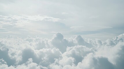 Cloudy sky background with thick, fluffy clouds in varying shades of blue, gray and white