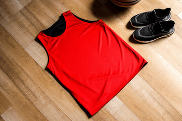 Red Basketball Jersey, Sneakers, and Ball Lay Ready on Wood Floor Creating