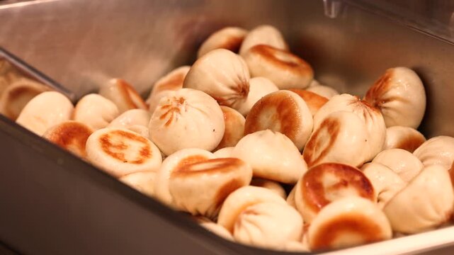 Close-up of golden fried dumplings, mini gyoza, Guo Tie, or Gun Mandu served on a plate, showcasing crispy texture, Asian street food, and delicious snack ready to eat.