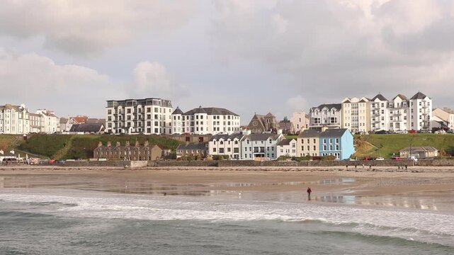 Dog walkers on the beach at Port Erin, Isles of Man. UK. Autumn