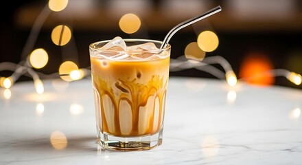 Refreshing iced coffee drink with creamy milk layers and a metal straw, beautifully illuminated by warm bokeh lights for a cozy ambiance