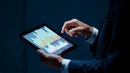 Executive using a digital tablet with financial dashboards, gestures guiding rising charts, symbolizing data-driven strategy, teamwork, and confident growth in modern corporate business - Powered by Adobe