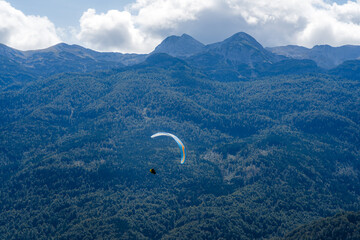 Paraglider Flying in Front of a Mountain Range over Lake Bohinj in the Julian Alps, Slovenia