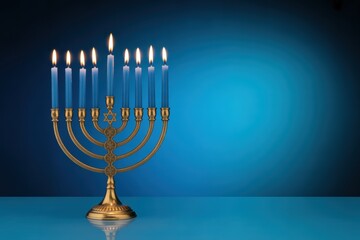 A hanukkah menorah with blue candles lit against a blue background in a studio setting