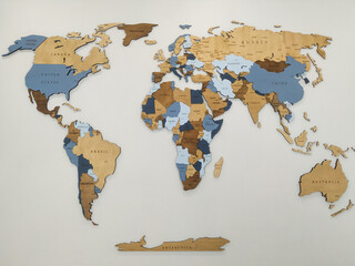 A wooden world map on a white wall. The map features various shades of blue and brown, highlighting different countries and regions © Александра Замулина