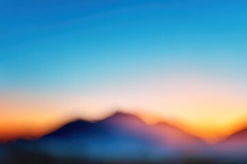 Obraz premium Sunset over blurred mountains revealing vibrant blue and orange hues in a calm evening sky
