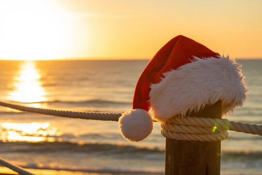 Christmas santa hat on beach at sunset tropical holiday vacation travel theme