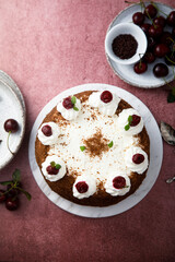 Chocolate cake with whipped cream and cherries