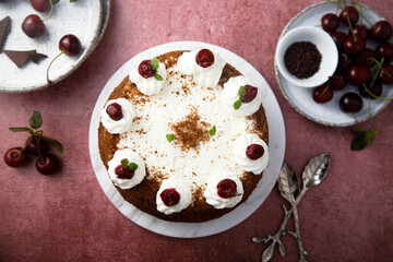 Chocolate cake with whipped cream and cherries