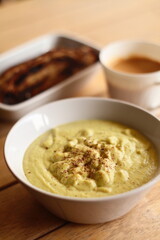 creamy avocado soup with sourdough in wide daytime side view with fresh ingredients