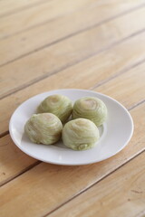 Cute Chinese Pastry or moon cake stuffed with salted egg yolk on wood plate