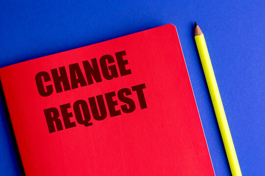  Change request written on red notebook with yellow pencil on blue background