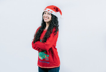 Smiling girl in Christmas hat with crossed arms. Portrait of smiling Latin girl in Christmas sweater with crossed arms, isolated