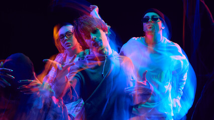 Obraz premium Hip hop dancers illuminated by neon blur in expressive motion. Concept of performing arts, street culture, lifestyle branding, and creative visual campaigns.