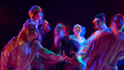 Street dance group illuminated by vibrant motion blur light. Concept of creative performance,...