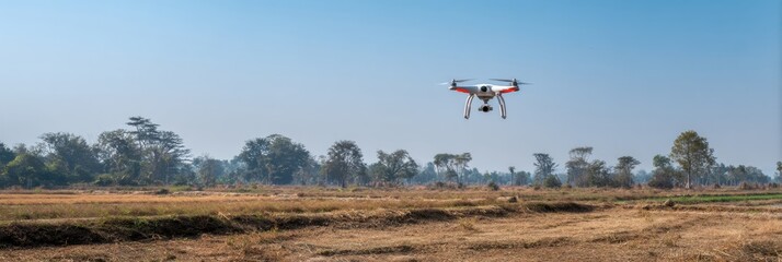 Fototapeta premium Drone Flying Over a Vast Field in a Clear Blue Sky During Daylight Hours