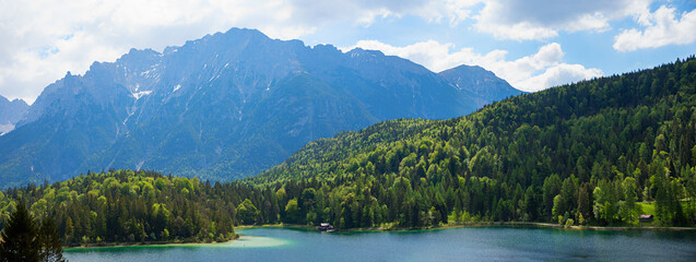 spring landscape lake Lautersee, green forest, view to Karwendel alps, upper bavaria