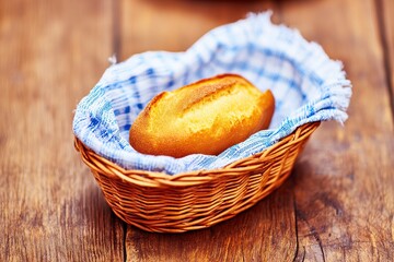 木製のテーブルの上の小さなバスケットに入ったフランスパンのスライス