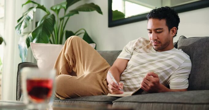 Thinking, writing or man in lounge with notebook, mindfulness practice or self reflection journal. Morning gratitude, goal setting or person contemplate day for stress relief, home or track thoughts