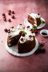 Chocolate cake with whipped cream and cherries