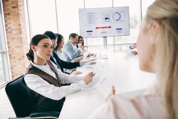 Fototapeta premium Diverse team collaborating in a modern office space during a business meeting with documents and presentations