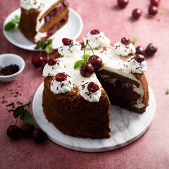 Chocolate cake with whipped cream and cherries