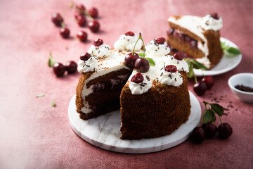 Chocolate cake with whipped cream and cherries