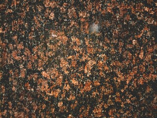 Close-up of a dark brown granite surface with speckled patterns.