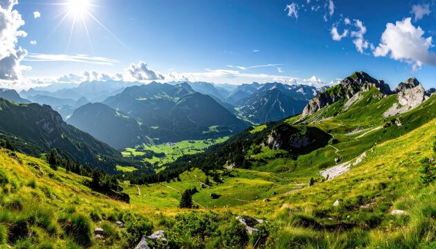 Expansive panoramic mountain landscape bathed in bright morning sunlight with rolling green hills dotted with woodland and open pasture under a clear blue sky with fluffy clouds - Powered by Adobe