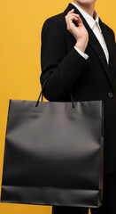 Woman in Black Suit Holding a Black Shopping Bag on a Yellow Background
