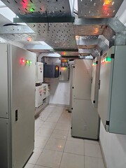 Electrical control panels in a utility room with cable trays.