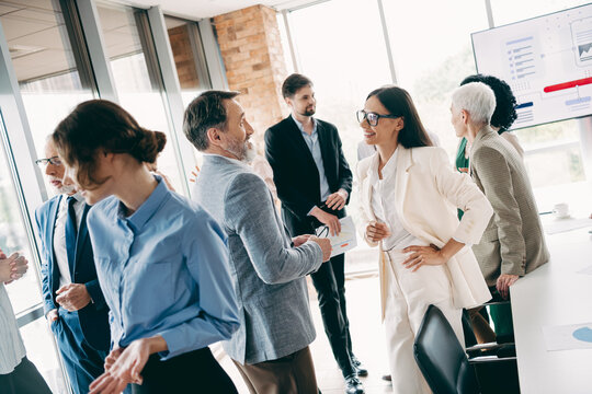 Group of diverse professionals networking and collaborating during a business meeting in a modern office environment