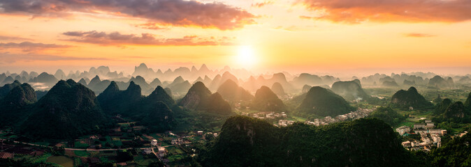 Panoramic view of the iconic karst mountain landscape and a small town during a spectacular sunset...