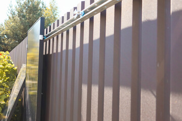 Solar panels waiting for installation next to a metal fence.