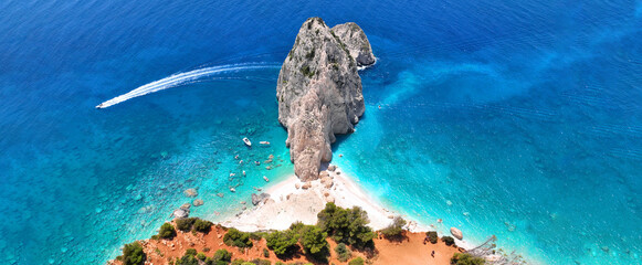 Aerial drone ultra wide panoramic photo of tropical exotic bay with crystal clear turquoise sea and sea caves forming a blue lagoon visited by small yachts and boats