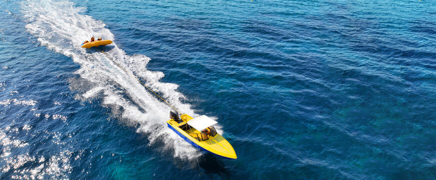 Aerial drone ultra wide panoramic photo of extreme power boat donut water-sports cruising in high speed in tropical emerald bay